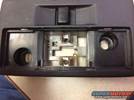 Interior of overhead console with light sockets and wiring exposed.