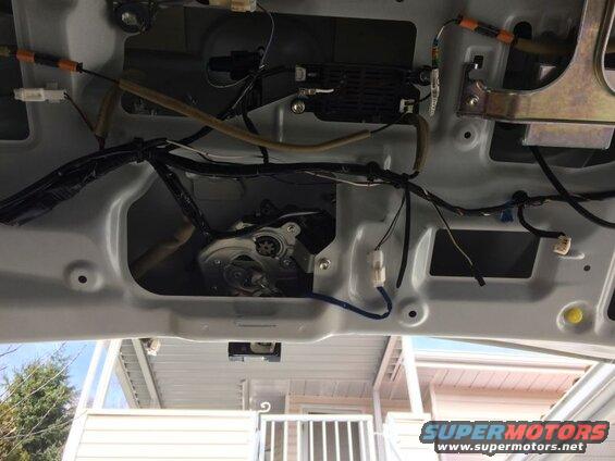 Interior of a car trunk lid showing wiring and liftgate actuator.