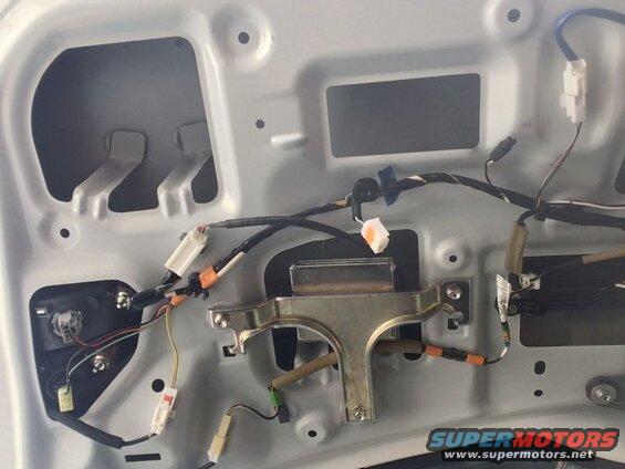 Interior of a car's rear door panel showing wiring and latch mechanism.