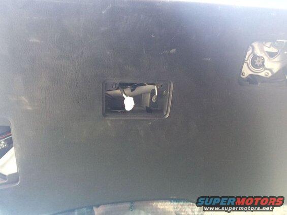 Interior headliner with open compartment and visible wiring, and a mechanical component.