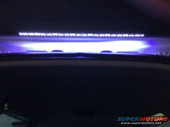Interior view of a car headliner with a blue LED light bar.