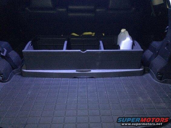 Cargo area of a 2009 Mazda CX-9 with a cargo organizer and a jug.