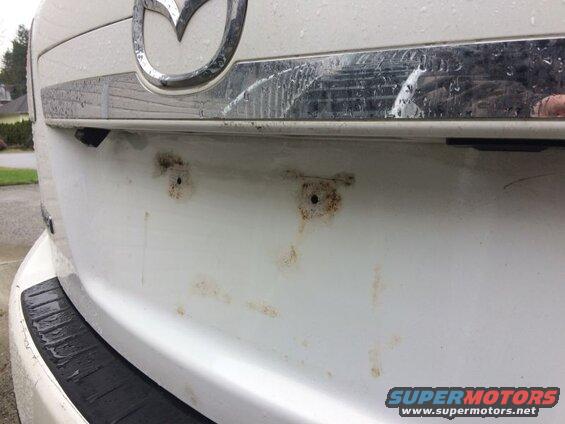 Plate removed; the damage caused by the license plate resting on the paint.