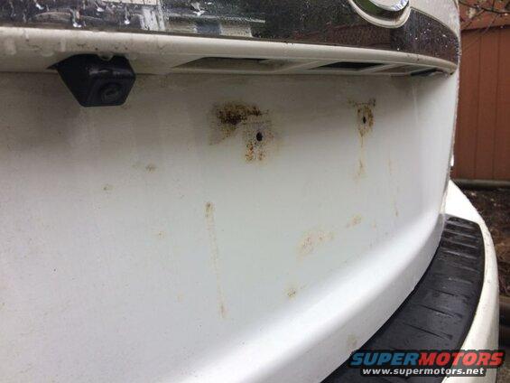 Plate removed; the damage caused by the license plate resting on the paint.