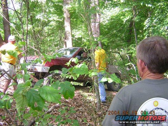 Red SUV stuck in trees, people standing nearby. Date stamp reads 2004.04.18