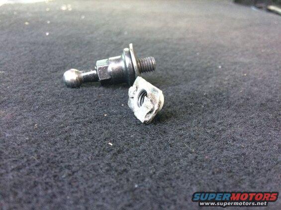 Broken ball joint stud and nut on dark carpet