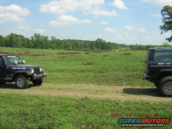 Two dark SUVs in a field, one with 'Delta 4x4 Club' visible