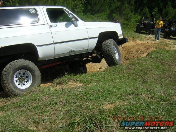 White 1984 Chevrolet K5 Blazer climbing a dirt hill with other Jeeps in the background