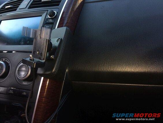 Car dashboard with phone mount near screen and controls