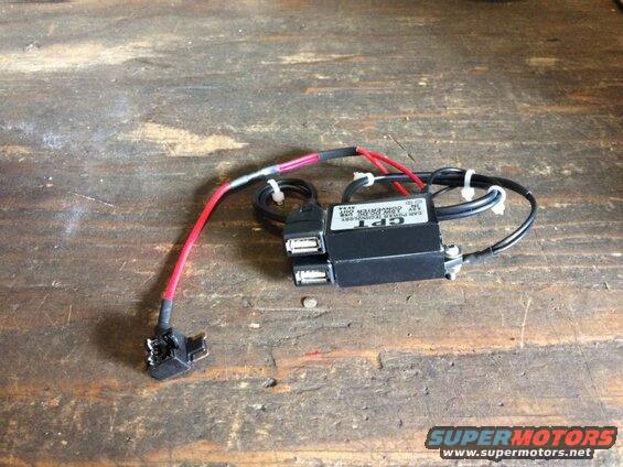 Black CPT car power converter with two USB ports and a red wire with fuse tap.