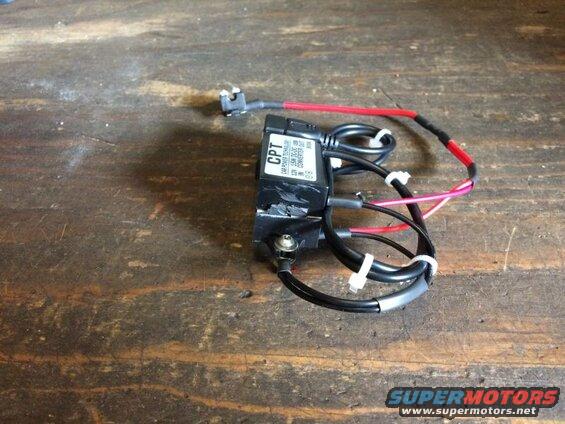 Black DC-DC converter with red and black wires on a wooden surface