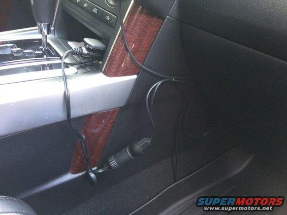 Car interior, center console with power adapter and cables.