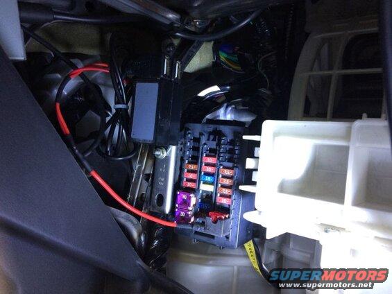 Car fuse box with visible fuses and wiring