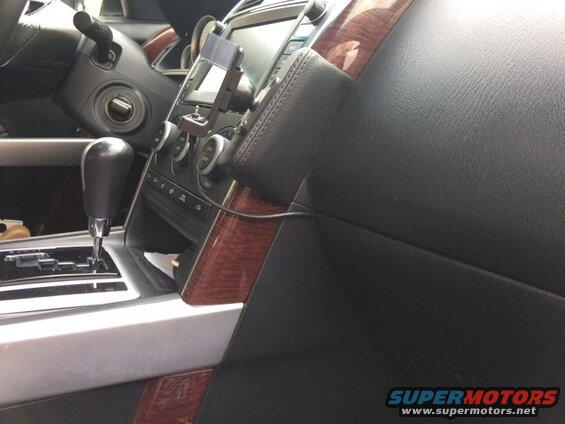 Car interior center console with gear shifter, climate controls, and phone mount.
