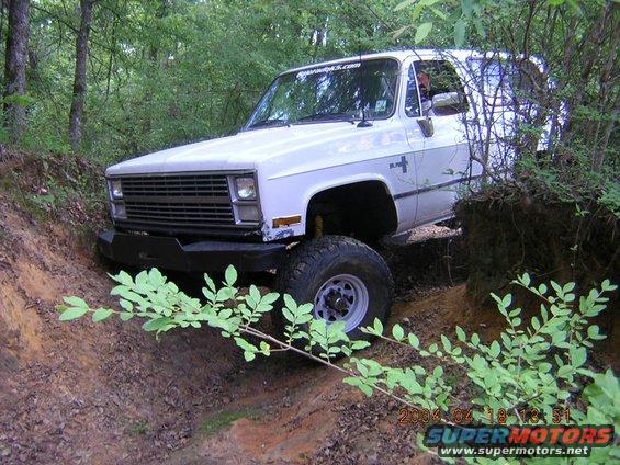 White 1984 Chevrolet K5 Blazer with aftermarket bumper navigating an off-road trail
