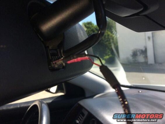 Wiring connected to a car's rearview mirror assembly.