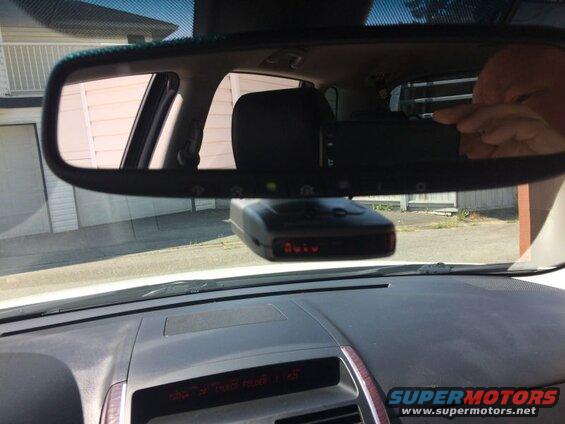 Car interior with radar detector on windshield.