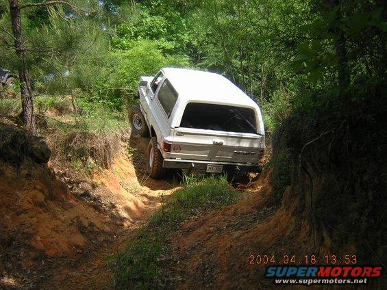 White 1984 Chevrolet Blazer driving off-road on a dirt trail