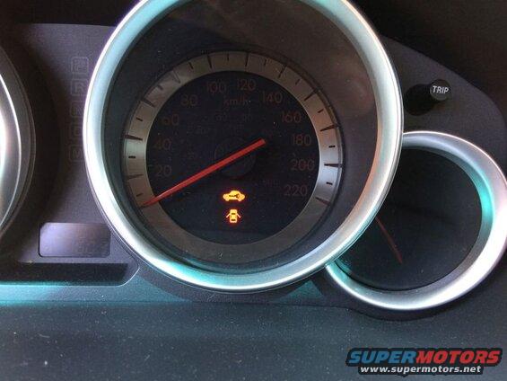 Car dashboard with speedometer and open door/trunk warning light.