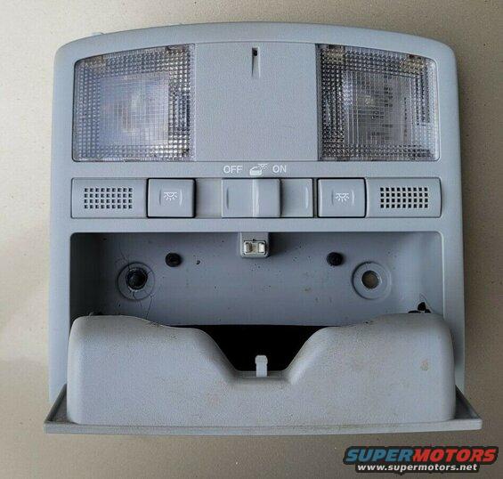 Gray overhead interior light console with map lights, switches, and storage compartment.
