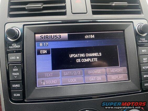 2009 Mazda CX-9 infotainment screen showing SiriusXM channel update progress.