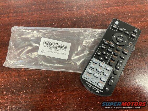 Remote control unit RC-DV331 and a packaged item on a wooden surface.