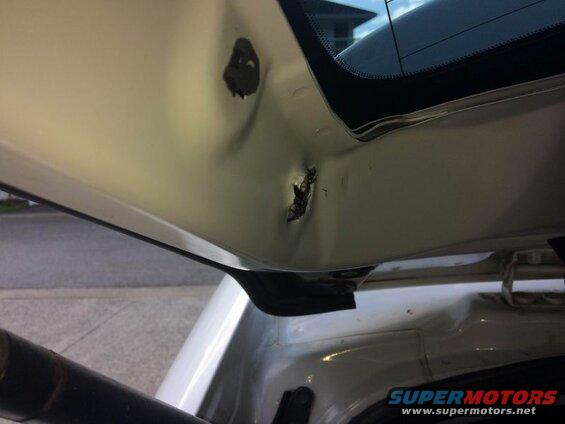 Close-up of damaged interior tailgate of a white vehicle.