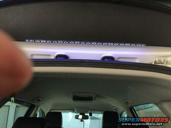 Interior rear hatch of a vehicle with LED strip lights installed along the top edge.
