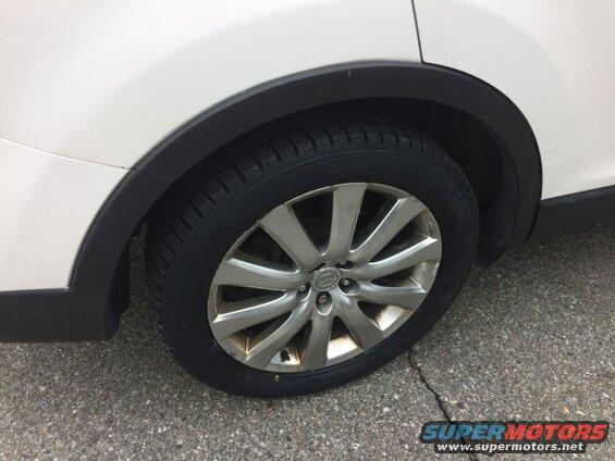 White SUV passenger side front wheel and fender flare
