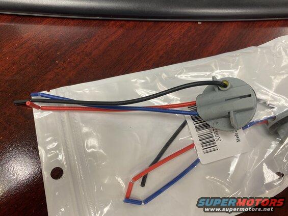Gray electrical connector with red, black, and blue wires on a plastic bag.