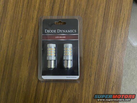 Diode Dynamics LED bulbs in packaging on a wooden surface.