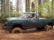 1979 Ford Bronco - A man drives a lifted green pickup truck through a muddy forest trail.