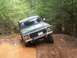 1979 Ford Bronco - Ford Bronco tackles a muddy obstacle on an off-road path.