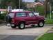 1994 Ford Bronco - Maroon 1994 Ford Bronco parked in a lot with a spare tire on the back.