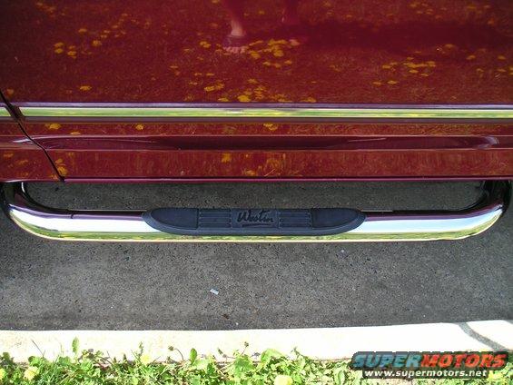 Chrome step bars with black textured pads on a dark red vehicle