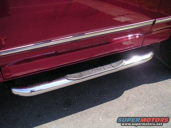Chrome Westin step bars mounted on a dark red vehicle side