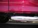 1994 Ford Bronco - Close-up of a red vehicle's side panel and chrome step bar.