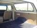 1979 Ford Bronco - The interior of a vintage SUV is shown, with a view of the rear cargo area and a glimpse of the outdoors through the side window.