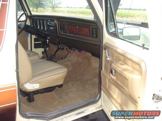 Interior of 1979 Ford Bronco showing tan seats, dashboard, and door panel