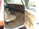 1979 Ford Bronco - The interior of a 1979 Ford Bronco features tan upholstery, a wood-grain accent on the dashboard, and a plush carpeted floor.
