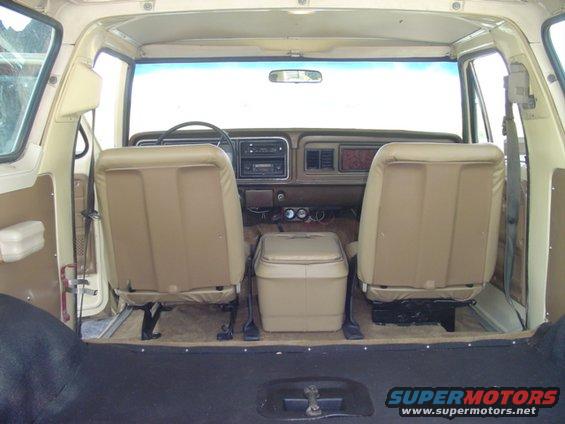 Interior view of beige SUV, showing front seats, dashboard, and center console cooler