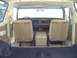 1979 Ford Bronco - The interior of a beige SUV is shown, front bucket seats, a dashboard with radio, and a portable cooler between the seats.