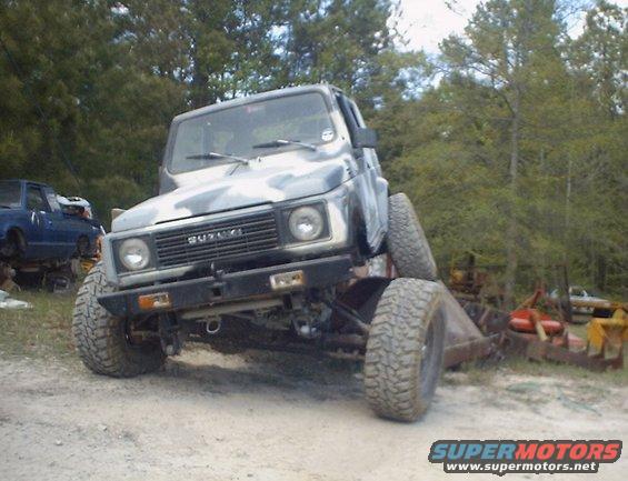Camouflaged Suzuki Samurai with lifted suspension