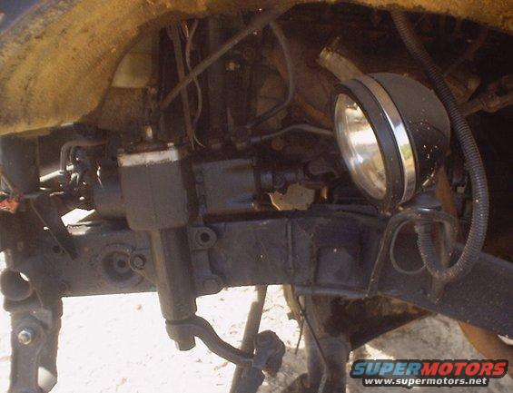 Undercarriage of a vehicle with a spotlight attached to the frame