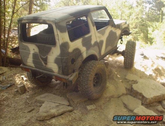 Suzuki Samurai with camouflage paint on rocky terrain