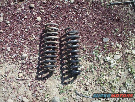 Two coil springs on the ground, one lighter than the other