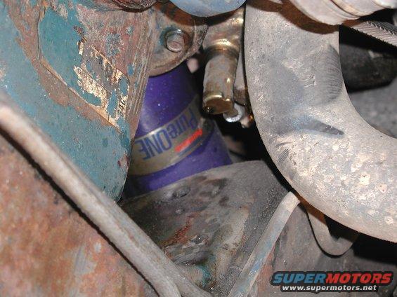 Close-up of a purple oil filter with 'PureONE' text, surrounded by engine components and hoses