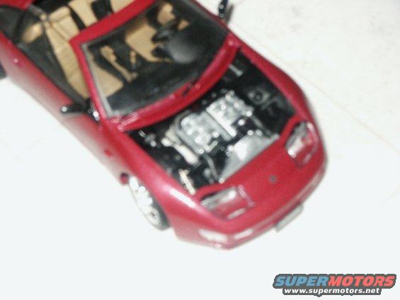 Red convertible with hood open, engine visible
