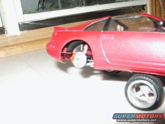 red model car with exposed suspension and wheels