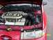 1995 Ford Taurus - The engine bay of a red 1995 Ford Taurus, showing the V6 engine and various components.